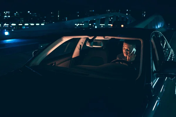 Человек, использующий мобильный телефон в машине ночью — стоковое фото