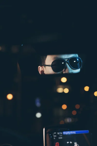 Hombre con gafas de sol mirando en el espejo del coche — Foto de Stock