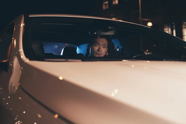 Junger asiatischer Mann sitzt im Auto — Stockfoto