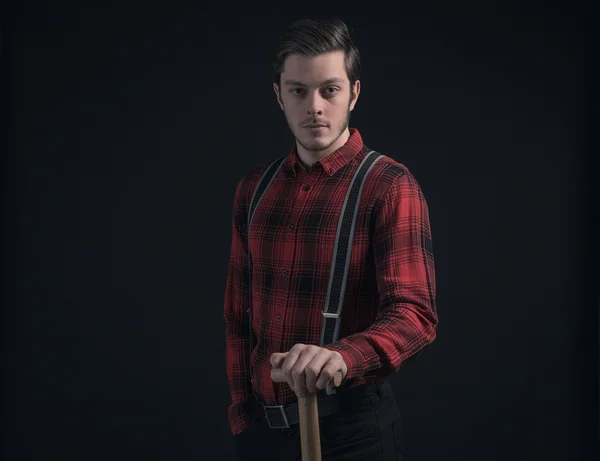 Young fashionable farmer in red checkered shirt holding hayfork. — Stock Photo, Image