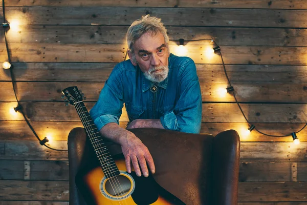 Muzikant met baard leunend op achterzijde stoel — Stockfoto