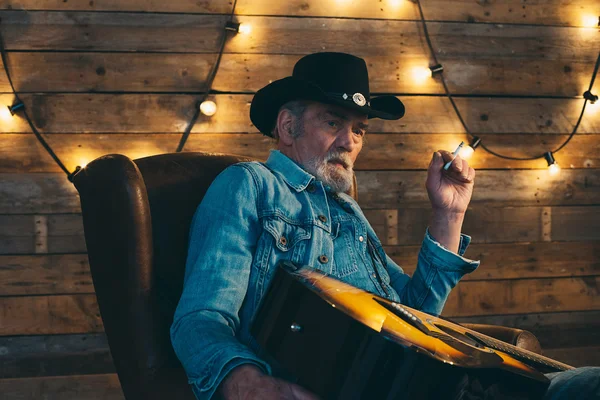 Smoking senior country and western guitarist — Stock Photo, Image