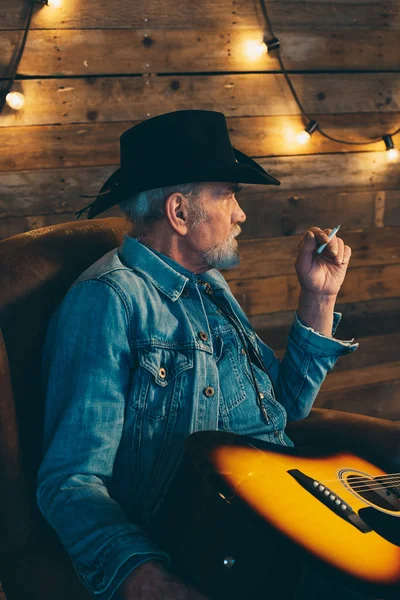 Smoking senior country and western guitarist — Stock Photo, Image