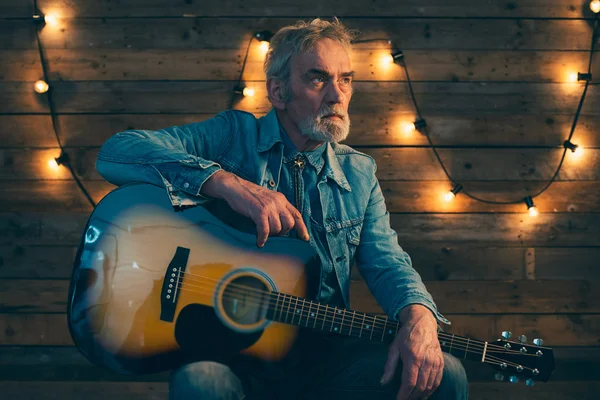 Senior guitarist with beard sitting on chair — Stock Photo, Image