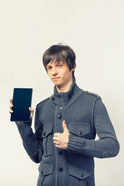 Porträt eines coolen jungen Mannes, der in lässiger Kleidung auf einem digitalen Tablet steht, während er auf weißem Hintergrund steht — Stockfoto