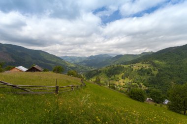 Yaz manzara. Ukrayna Karpatlar dağ köyünde. Dramatik gökyüzü.