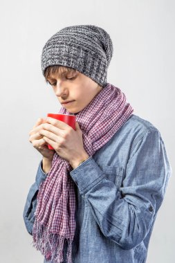 Genç sevimli donmuş genç bir eşarp ve kırmızı çay bardağı ile portresi