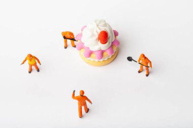 Minyatür insanlar pasta, yemek ve dekorasyon konseptini değiştirirler. Herhangi bir soruna toplu çözüm kavramı. Yakın çekim görünümü.