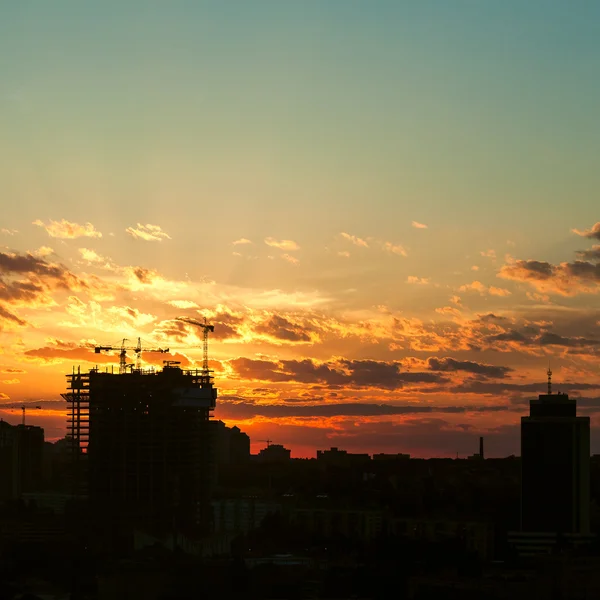 Silueta de la grúa torre en el sitio de construcción con el fondo del edificio de la ciudad —  Fotos de Stock