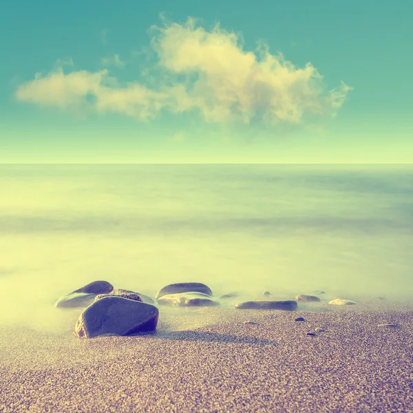 Minimalista paisaje marino brumoso con rocas a larga exposición. Salida del sol costero . — Foto de Stock