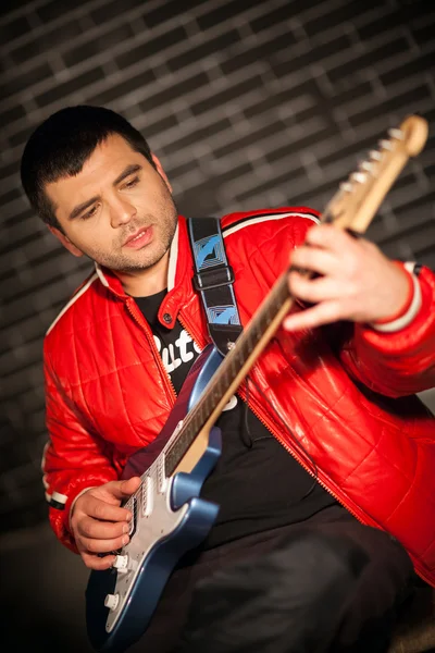 Guapo músico tocando rock and roll la guitarra eléctrica — Foto de Stock