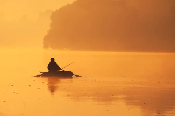 พระอาทิตย์ตกที่สวยงามริมแม่น้ํา ชาวประมงอยู่ในเรือ — ภาพถ่ายสต็อก