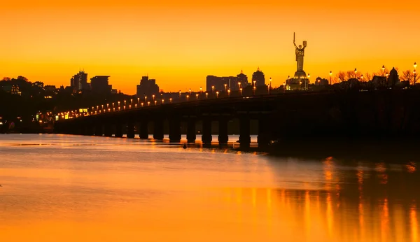 Puesta de sol sobre puente y río en la ciudad. Kiev, Ucrania —  Fotos de Stock