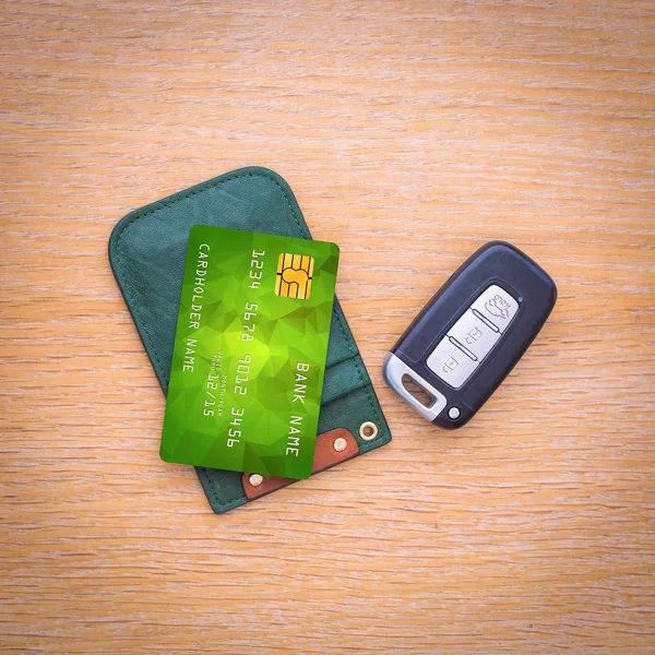 Car key with remote control and credit card on the wooden table surface — Stock Photo, Image