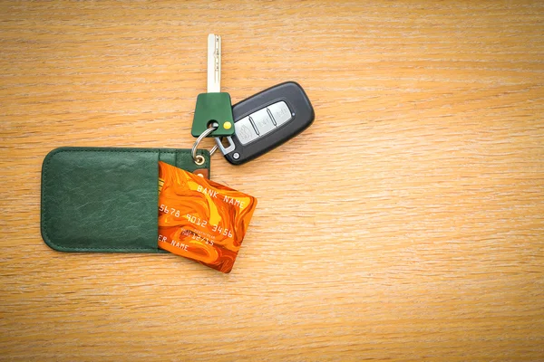 Car key with remote control and credit card on the wooden table surface — Stock Photo, Image