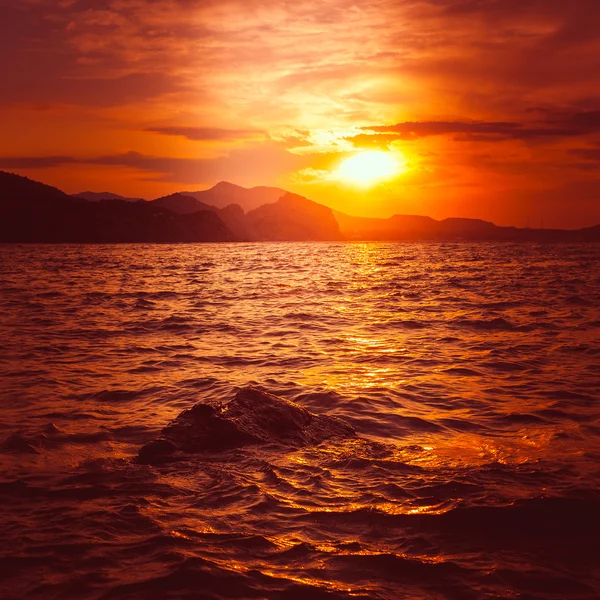 Beau coucher de soleil doré au-dessus de la mer et la montagne — Photo