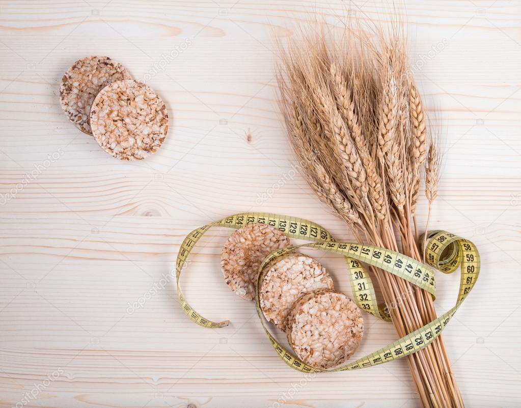 Rustic bread and wheat on an old planked wood table