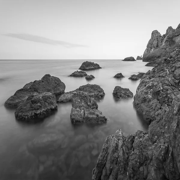 Minimalistische neblige Meereslandschaft mit Felsen bei langer Belichtung. schwarz-weiß — Stockfoto