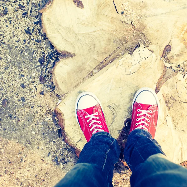 Ung man fötterna i röda sneakers på kullerstensväg — Stockfoto