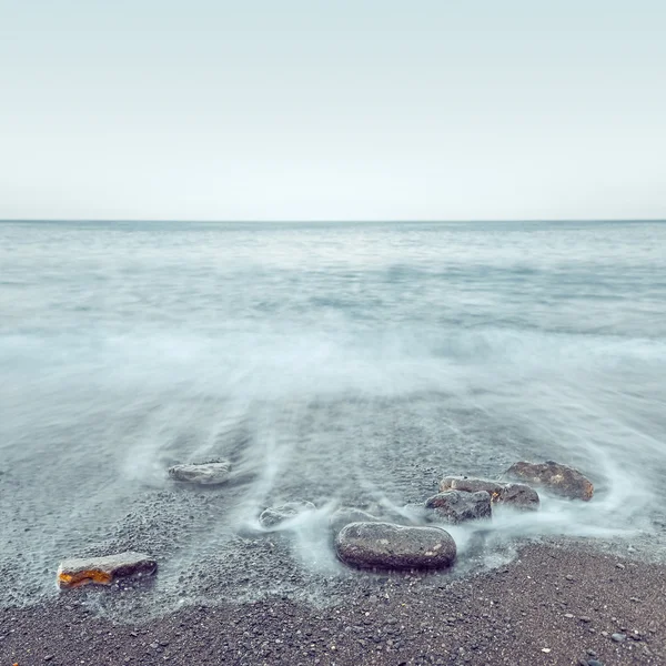 Minimalistische neblige Meereslandschaft mit Felsen bei langer Belichtung — Stockfoto