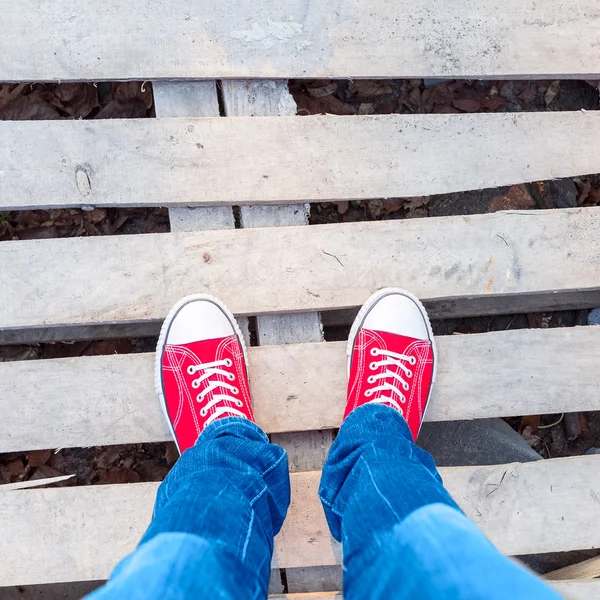 Young man feet in red sneakers on road — Stock Photo, Image