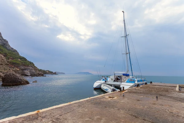 Мінімалістичний морський пейзаж з камінням і кораблем — стокове фото