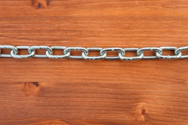 Metal chain links on wooden background
