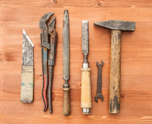 Velhos instrumentos de construção enferrujados no fundo de madeira — Fotografia de Stock