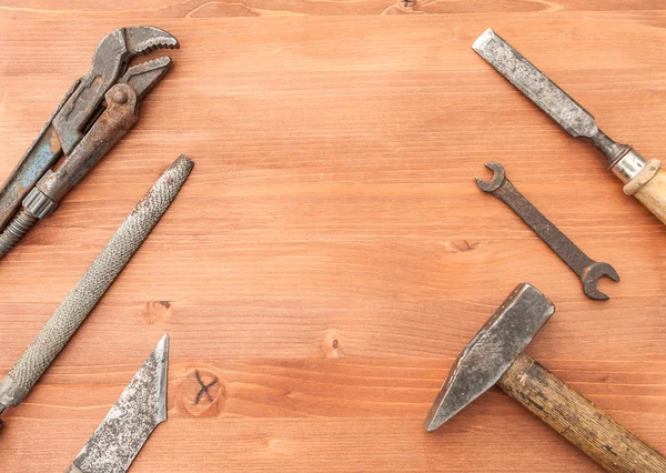 Velhos instrumentos de construção enferrujados no fundo de madeira — Fotografia de Stock