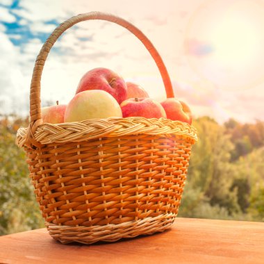 güneşli bir gün, Bahçe arka plan karşı ahşap masa üzerinde bir sepet elma