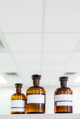 medicine bottle with blank label on a shelf in the laboratory clipart