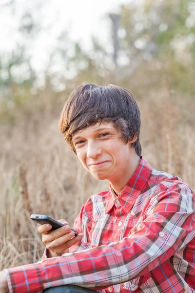 Lächelnder Student telefoniert im Stadtpark — Stockfoto