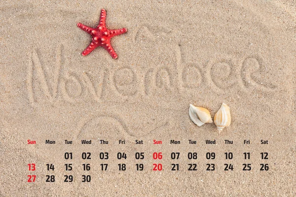 Ημερολόγιο φωτογραφιών με αστερίες και κοχύλια σε παραλία με άμμο. Novemb — Φωτογραφία Αρχείου
