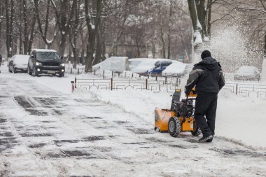 Kiev, Ukrayna - 09 Ocak 2016: Kaldırımlar kar temizleme makinesi ile kardan bir adam temizler.