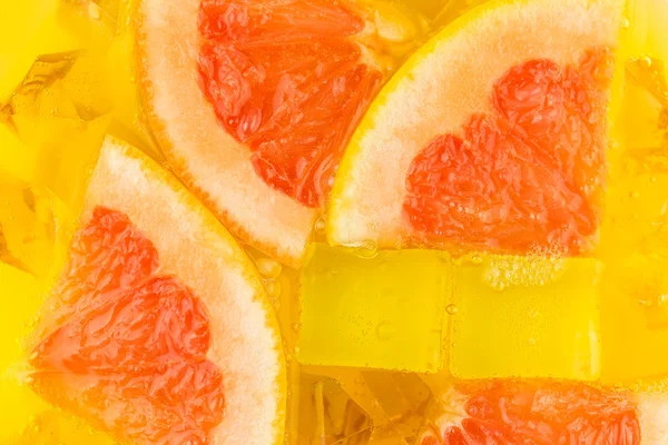 Close-up de cubos de gelo em suco de laranja e toranja — Fotografia de Stock