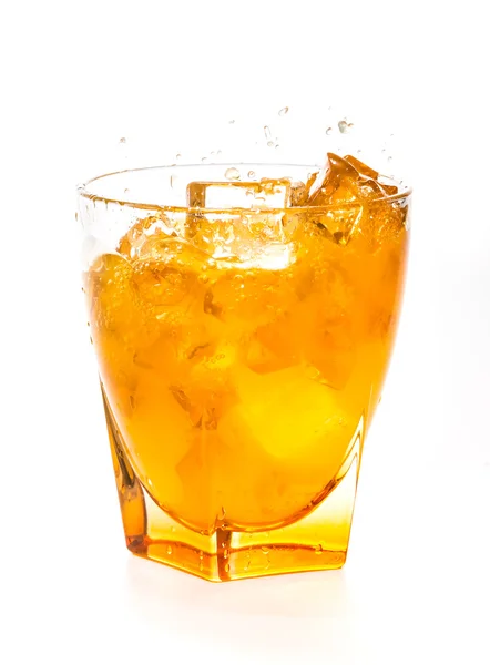 Spritzender Orangensaft im Glas auf weißem Hintergrund — Stockfoto