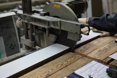 PVC pencere pervazını testereyle kesen bir fotoğrafçı. Endüstriyel kavram.