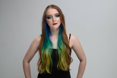 Kafası karışmış düz saçlı, kafası karışık bir kadının yatay portresi. Parmağını dişlerinin üzerinde tutuyor. Ne seçeceğini bilmemek zor bir seçim..