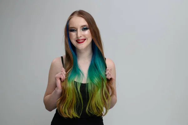 Foto retrato de una chica caucásica con el pelo largo teñido sonriendo sobre un fondo blanco —  Fotos de Stock