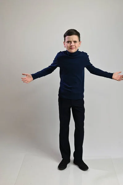 Teen boy in full growth in dark clothes on a white background — Stock Photo, Image