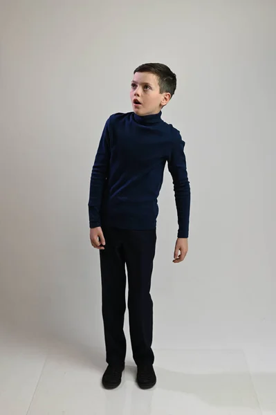 Teen boy in full growth in dark clothes on a white background — Stock Photo, Image