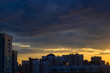 Şehirde akşam gökyüzü ile batan güneşin fotoğrafı.