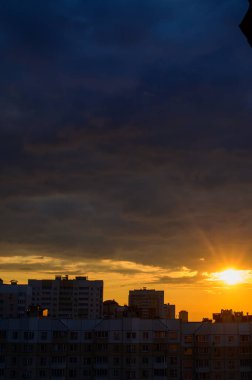 Şehirde akşam gökyüzü ile batan güneşin dikey fotoğrafı