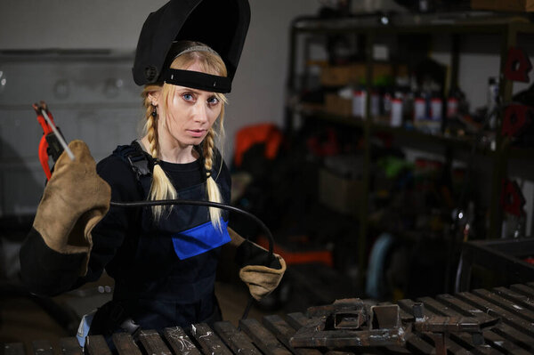 Photo of cute caucasian girl welder in mask