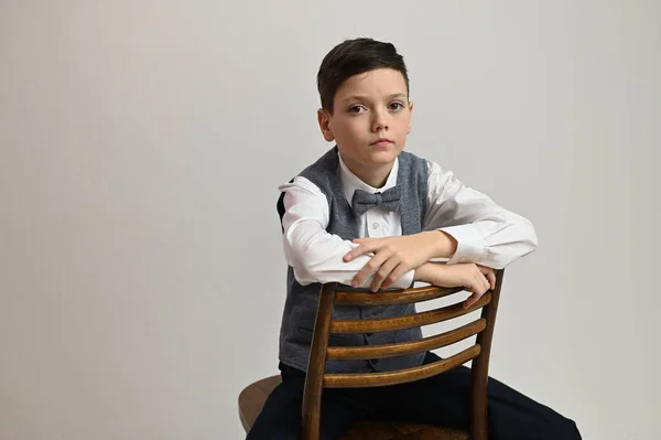 Gri Arka Planda Sandalyede Oturan Ciddi Bir Gencin Portre Fotoğrafı — Stok fotoğraf