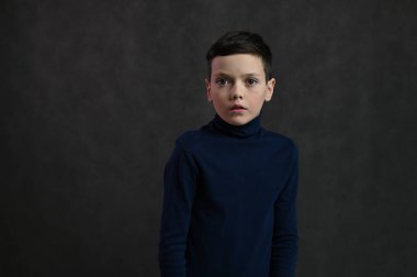 Gri arka planda korkmuş beyaz bir gencin portresi.