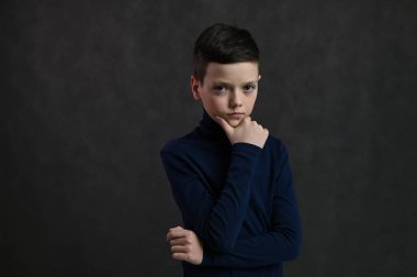 Gri arka planda düşünceli beyaz bir gencin portresi.