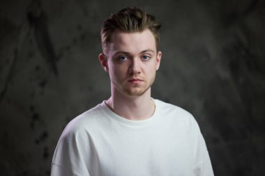 Gri arka planda beyaz bir adamın portresi.