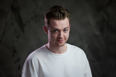 Gri arka planda beyaz bir gencin portresi.