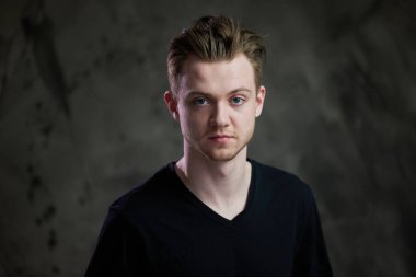 Gri arka planda beyaz bir gencin portresi.